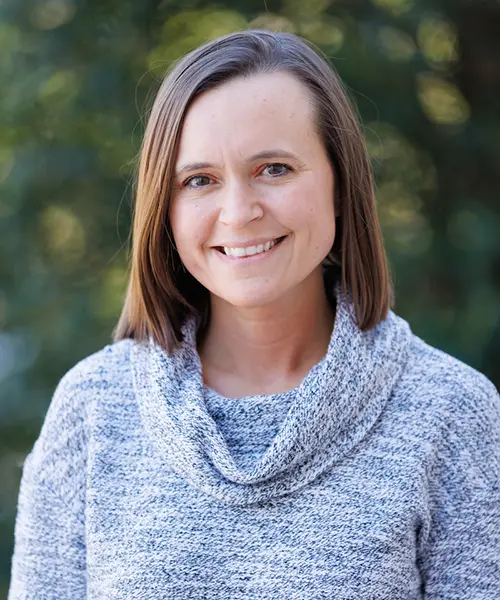 headshot of lori hill wearing a grey sweater