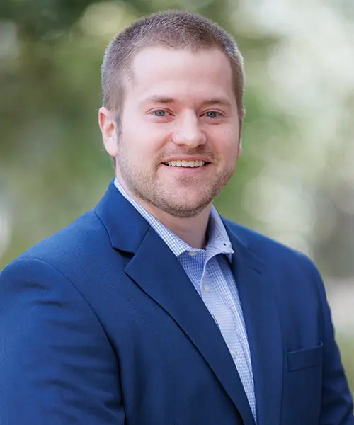 headshot of will adams wearing a blue suit